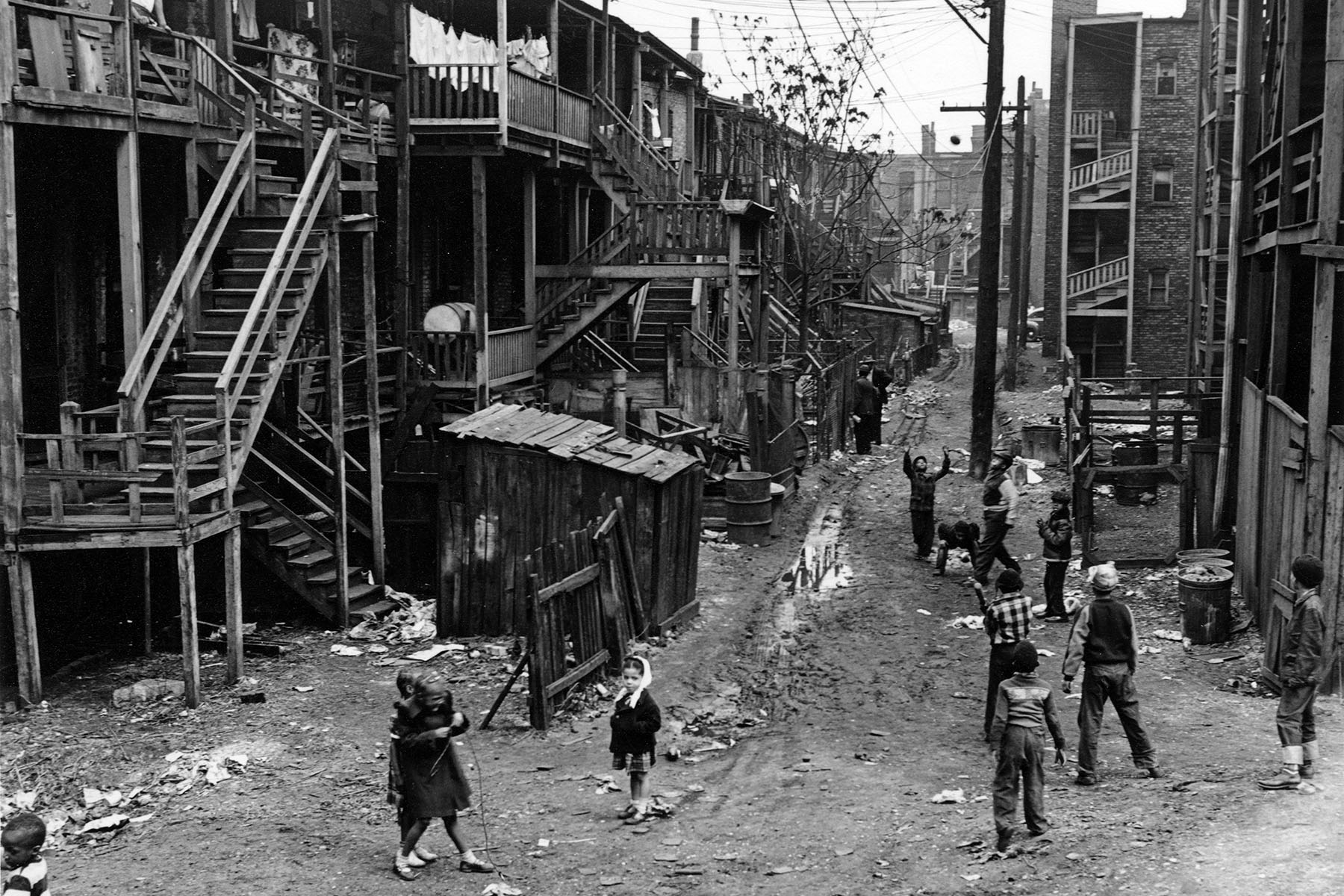 Children play in a muddy back street alley of Chicago's South Side in 1951.
