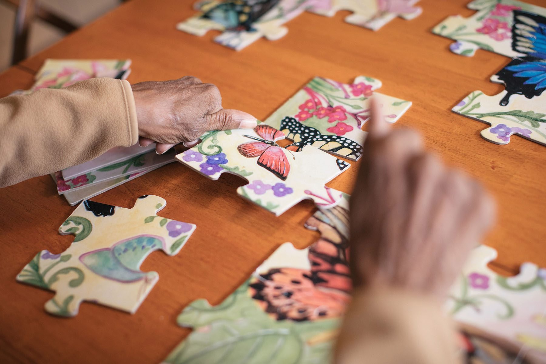 An older woman puts together a puzzle in the home of her daughter where she lives.