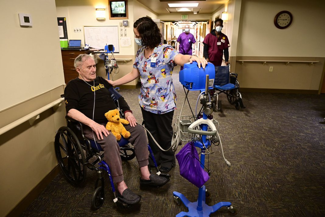 A caregiver checks a resident in a wheelchair
