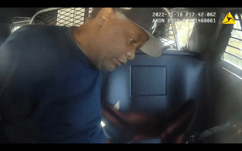 A screenshot of Dexter Barry handcuffed in a Jacksonville police car taken from body camera.
