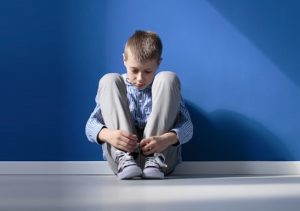 Boy sitting on the floor, sad