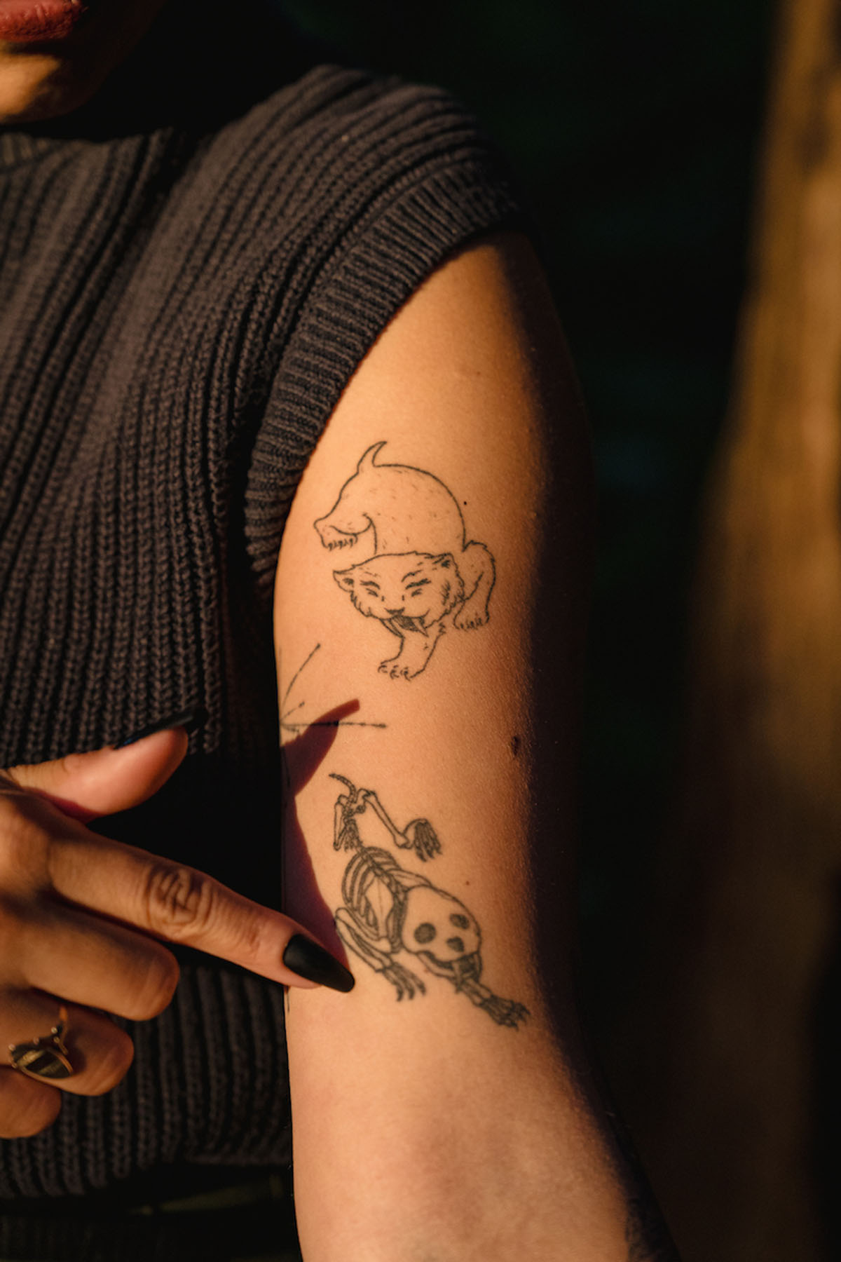 Michelle Barboza “MB” Ramirez shows off their smilodon tattoos.