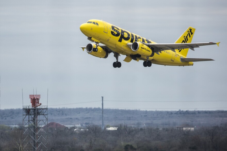 A yellow Spirit Airlines passenger jet taking off from ABIA